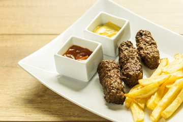 Traditional Romanian Mici And Fries With Ketchup And Mustard