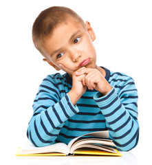 Little boy is tired to read his book