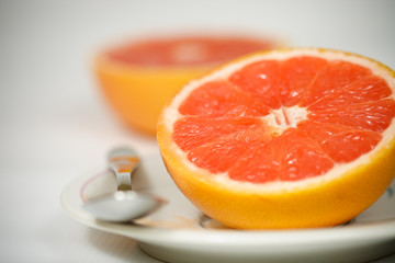 Fototapeta na wymiar Halved red grapefruit on plate