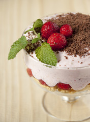Dessert with curd cream, cereal, strawberries and chocolate.