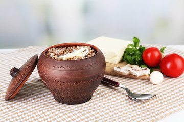 Buckwheat in pot with butter and vegetables closeup