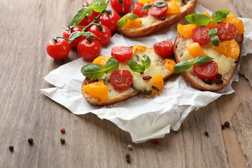 Tasty bruschetta with tomatoes, on old wooden table