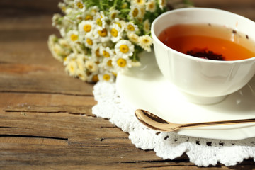 Cup of fresh herbal tea on wooden table