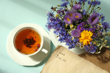Cup of fresh herbal tea on table