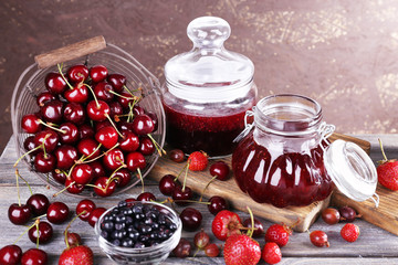 Berries jam in glass jars on table, close-up