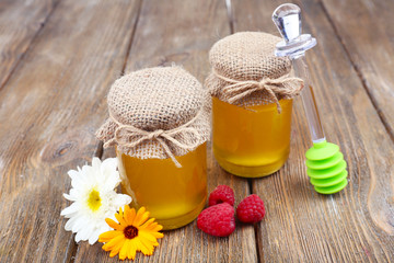 Obraz na płótnie Canvas Jar full of delicious fresh honey and wild flowers