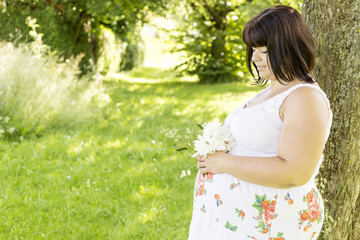 Werdende Mama schaut auf ihren Bauch