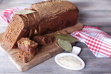 Fresh homemade bread on napkin, on color wooden background