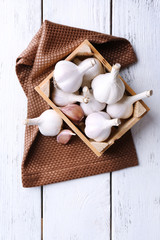 Fresh garlic in box, on wooden background