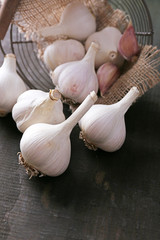Garlic in basket on black wooden background