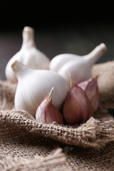 Garlic on sackcloth, on black wooden background