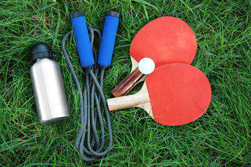 Assortment of sport equipment on green grass background