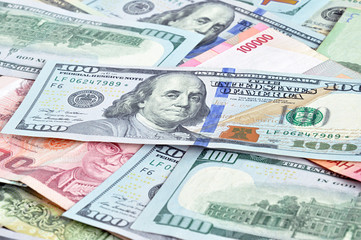 Money in multi currencies with 100 USD bill on top