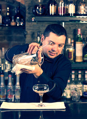 young man working as a bartender in a nightclub bar