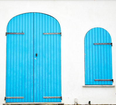 White wall with blue door and window