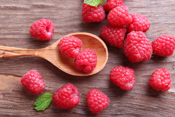 Ripe sweet raspberries in spoon on table close-up