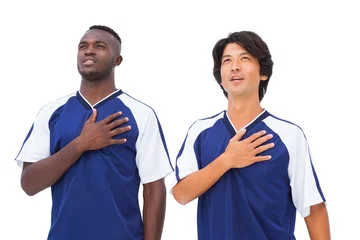 Foto op Canvas Football players in blue with hands on heart © WavebreakMediaMicro
