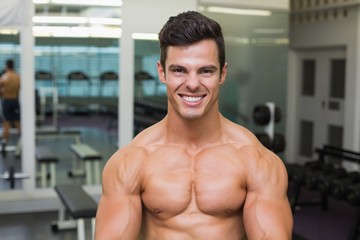 Obraz premium Smiling shirtless muscular man in gym