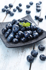 Delicious blueberries on plate on table close-up