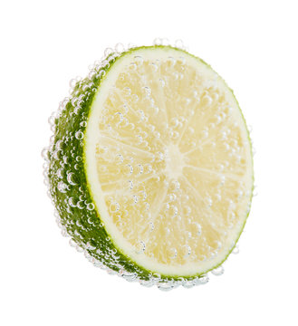 Fresh lime in water with bubbles, isolated on white