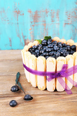 Tasty cake Charlotte with blueberries on wooden table