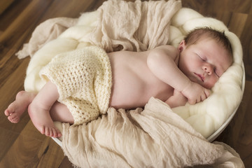 Newborn Kleiner Bub schlafend in einer Schale