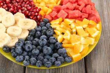 Sliced fruits on plate on wooden table