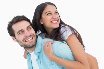 Happy casual man giving pretty girlfriend piggy back