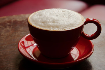 coffee mug with frothed milk in an atmospheric cafe
