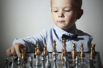 Little boy playing chess.Little genius Child.Chessboard