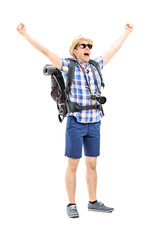 Smiling male hiker with raised hands gesturing happiness