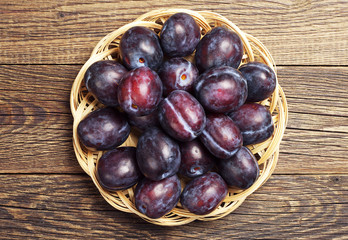 Plate with plums on table