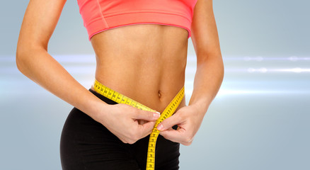 close up of female hands measuring waist