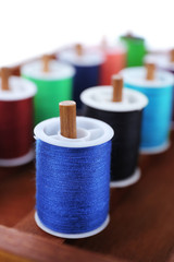 Colorful threads for needlework in wooden box close up