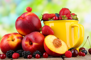 Peaches and berries on table on natural background