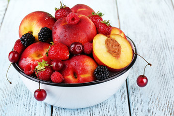 Peaches and berries in bowl on table