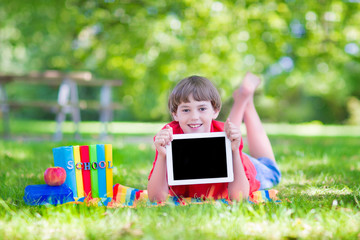 Happy school boy with a tablet pc