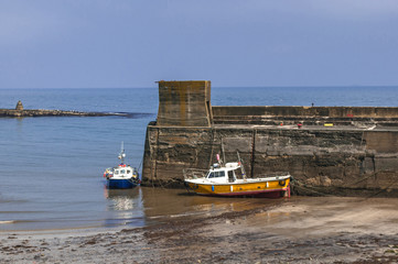 Fototapeta premium Fishing Boats Moored by Harbour Wall