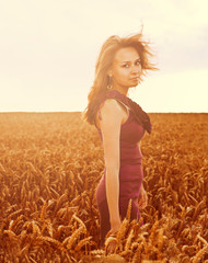 Beautiful woman walking on wheat field