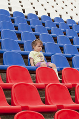 Ребёнок на трибуне стадиона эмоционально наблюдает