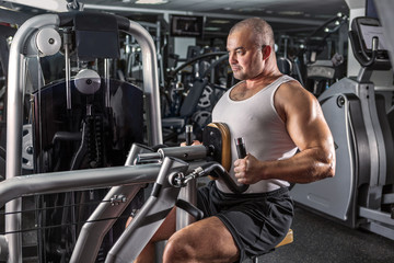 Fototapeta na wymiar Man doing workout with pull-down machine