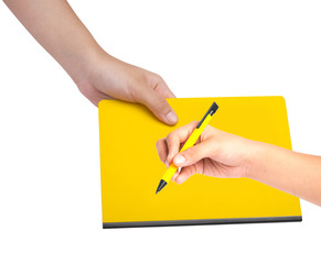 Female hand writing on yellow book
