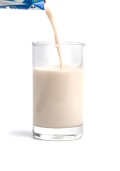 Pouring milk t into glass isolated