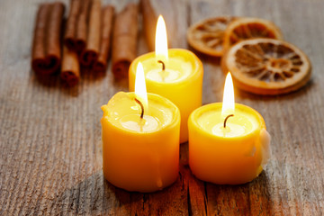Obraz na płótnie Canvas Beautiful candles and juicy oranges on jute table cloth