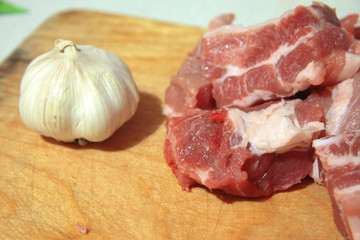 Fresh meat and fresh garlic laying on the kitchen desk
