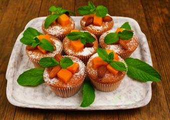 Tasty pumpkin muffins on wooden table