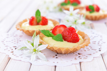 Tasty tartlets with strawberries on table close-up