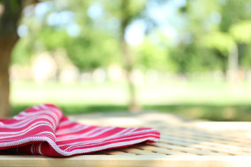 Wooden table with tablecloth, outdoors