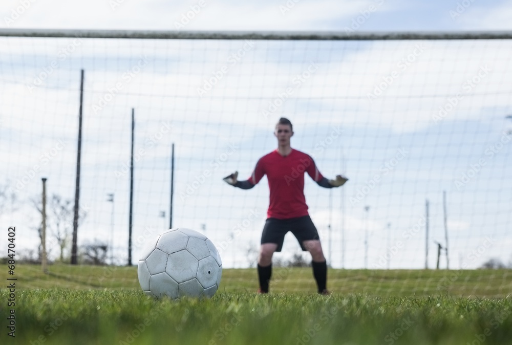 Poster goalkeeper in red ready to make a save