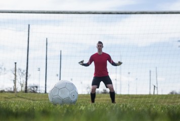 Goalkeeper in red ready to make a save